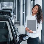 Gerente feminina em concessionária mostrando veículo