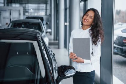 Gerente feminina em concessionária mostrando veículo