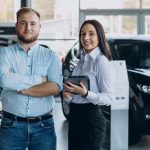 Homem escolhendo carro com vendedor em showroom